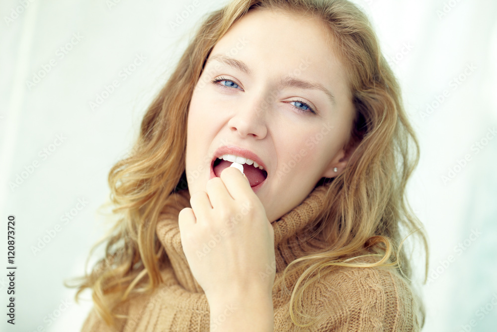 Portrait of woman taking pill and looking at camera Portrait of woman taking pill and looking at camera