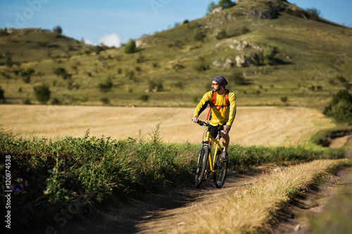 young bright man on mountain bike