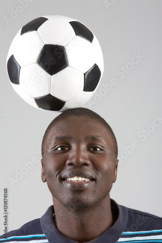 Smiling man bouncing soccer ball off head