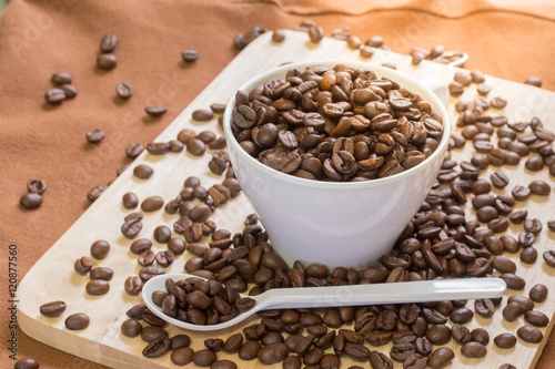 Coffee Cup with coffee beans on wood of coffee beans background