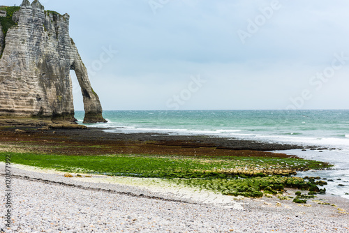 The beach and stone cliffs in Etretat, France photo