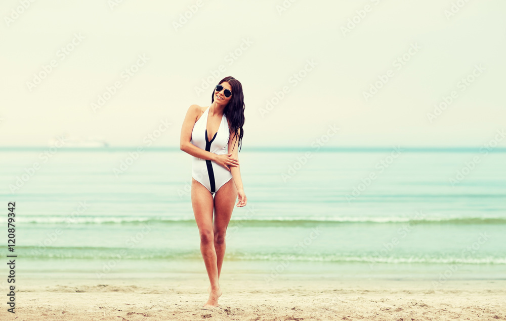 young woman in swimsuit posing on beach