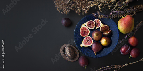 Свежий инжир на синей тарелке с осенними фруктами