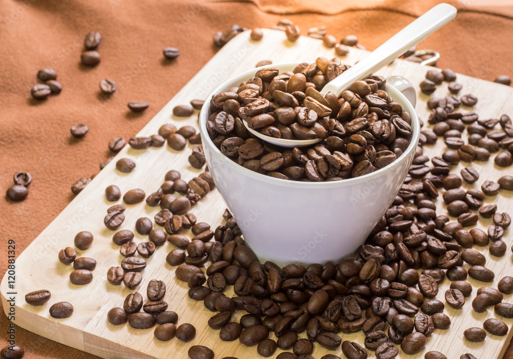 coffee beans on spoon and in cup with on wood coffee beans on spoon and in cup with on wood