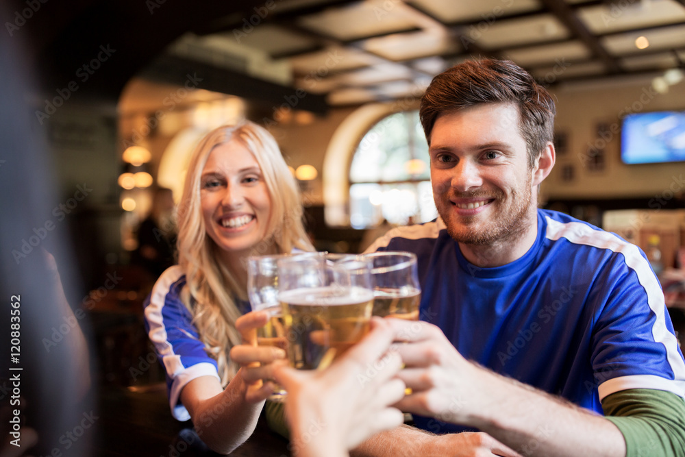 football fans clinking beer glasses at sport bar