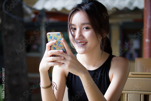Portrait of thai adult student university beautiful girl using her smart phone