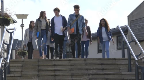 Group of Students walking down steps in a city. They are wearing casual clothing and smiling.