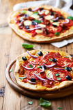 Home baked pizza with tomatoes, red onion and salami
