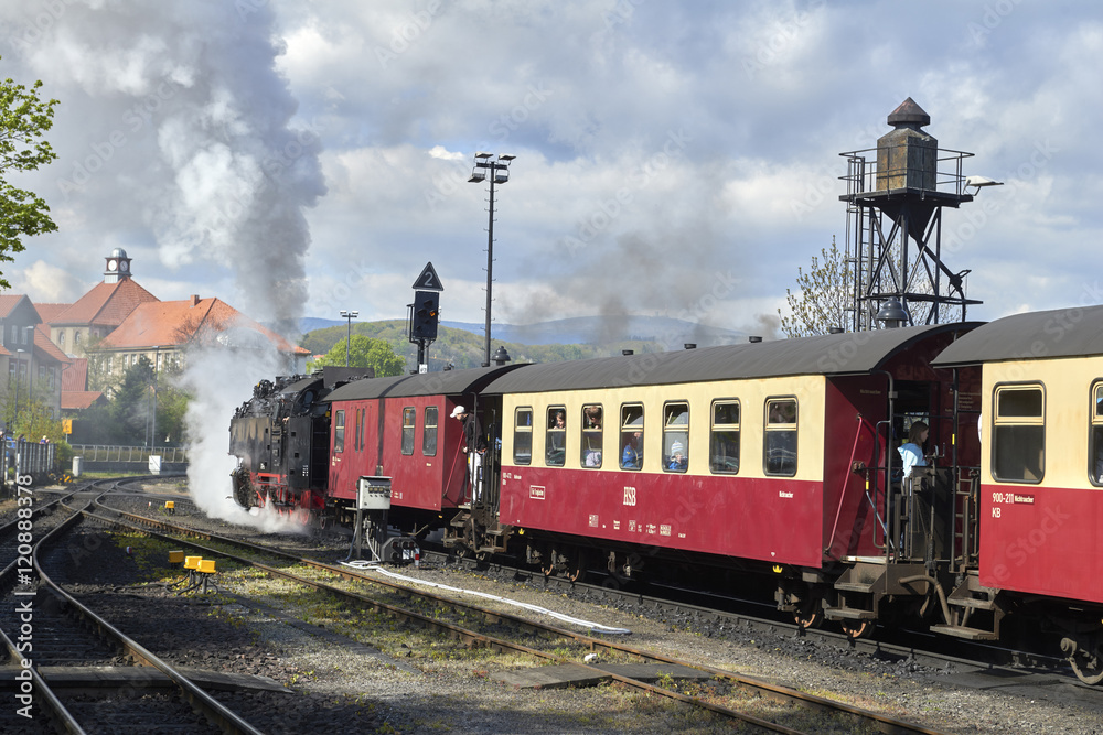 Fototapeta premium WERNINGERODE, HARZ, GERMANY. Steam train of the Harzer narrow gauge railway leaving the station of Werningerode. The trains to the Brocken mountain are popular with tourists
