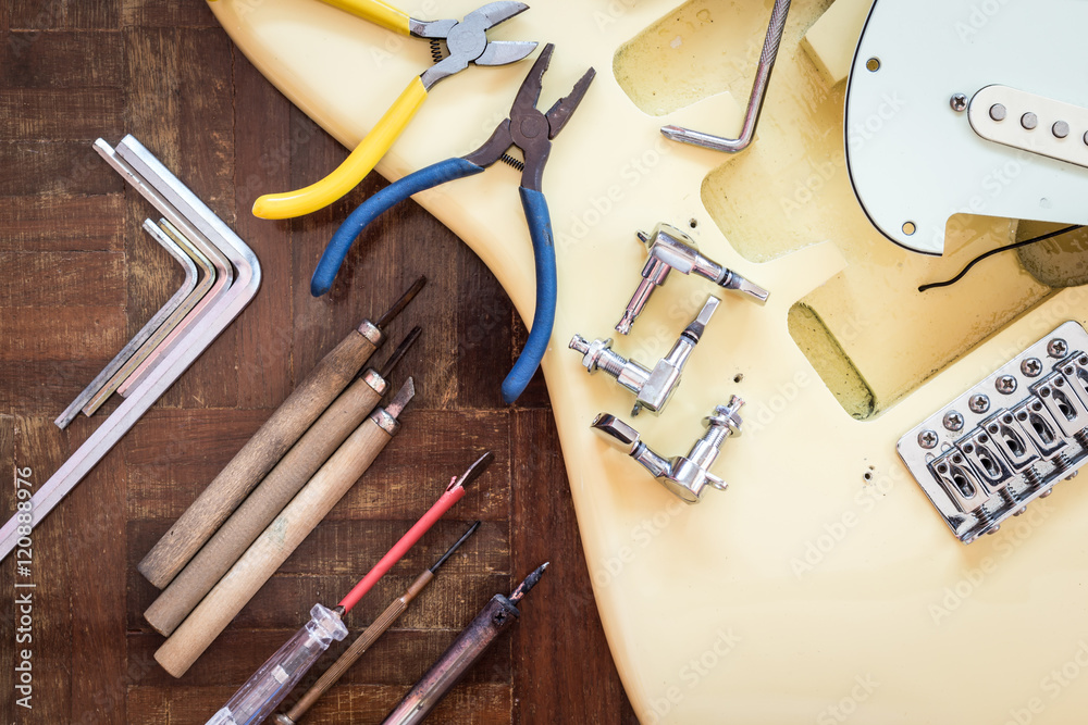 Obraz premium yellow electric guitar on wood in repair & luthier workshop, fixing & musical instrument repairing concept