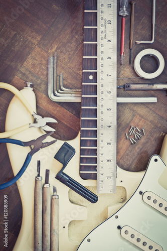 yellow electric guitar on wood in repair & luthier workshop, fixing & musical instrument repairing concept photo