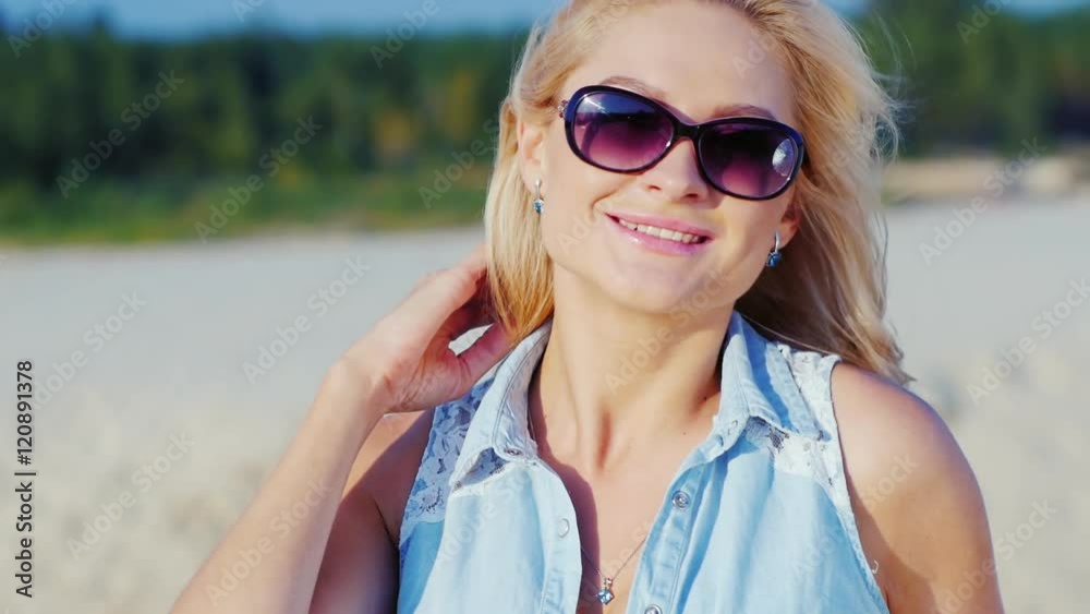 Beautiful blonde woman smiling at the camera, posing. Summertime at the beach Beautiful blonde woman smiling at the camera, posing. Summertime at the beach