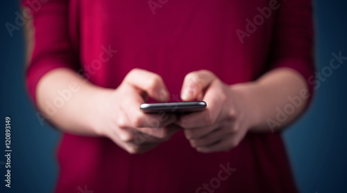 Young woman holding smarthphone in hand © ra2 studio