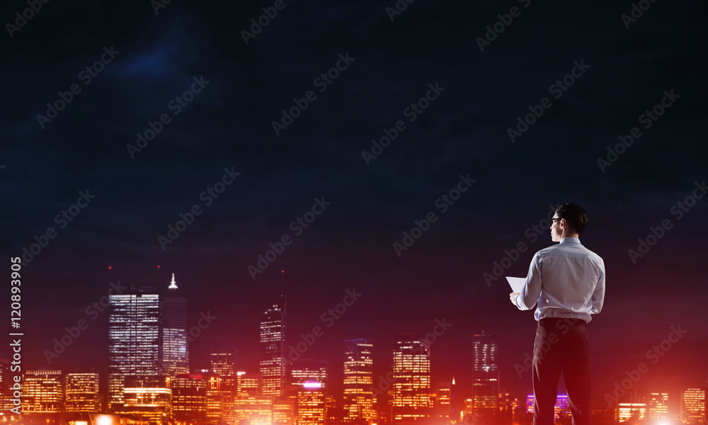 Businessman viewing night glowing city