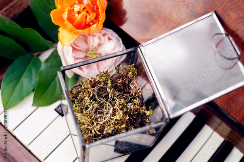 box with wedding rings and bride's bouqiet on piano keys.  photo