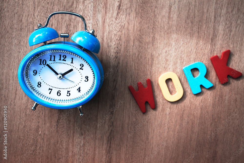 clock and work word writen on wooden background clock and work word writen on wooden background