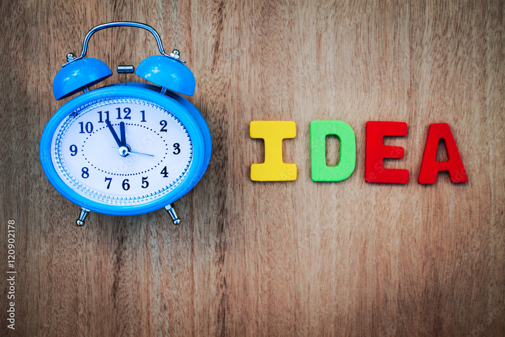 clock and idea word writen on wooden background clock and idea word writen on wooden background