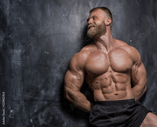 Muscular bodybuilder guy over darck background photo