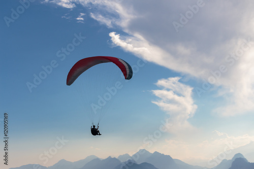 Parachute and human silhouette. Blue sky and adventure.