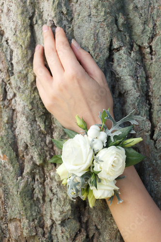 Photo White and green wrist corsage on a hand