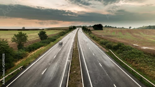 Time Lapse of fast speeding vehicles on rural motorway M54 in UK. Smooth transition from late eveing throught sunset and twilight.