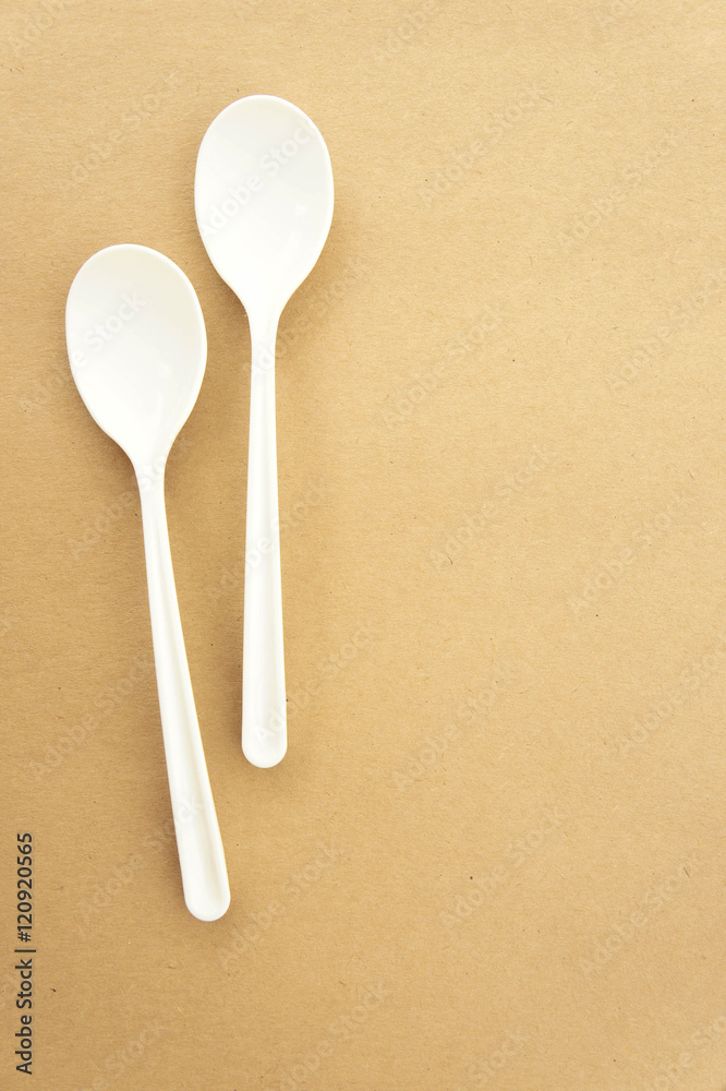 Twin spoons on brown background ,White spoon, The device is one Twin spoons on brown background ,White spoon, The device is one