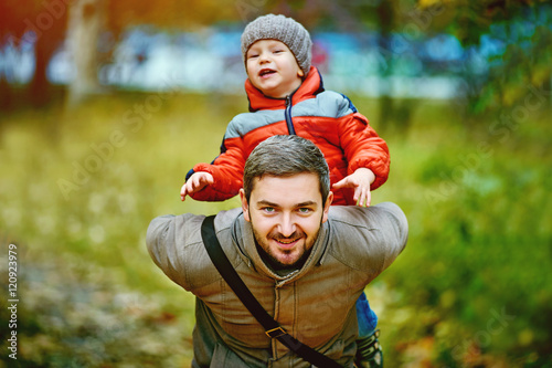 happy young father playing with son in autumn Park