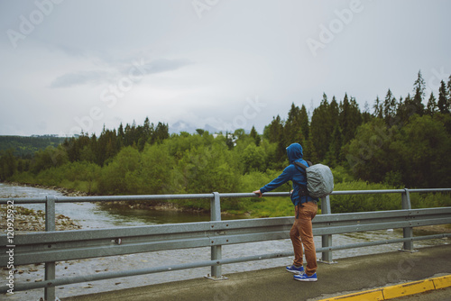 male tourist standing beside the mountain river