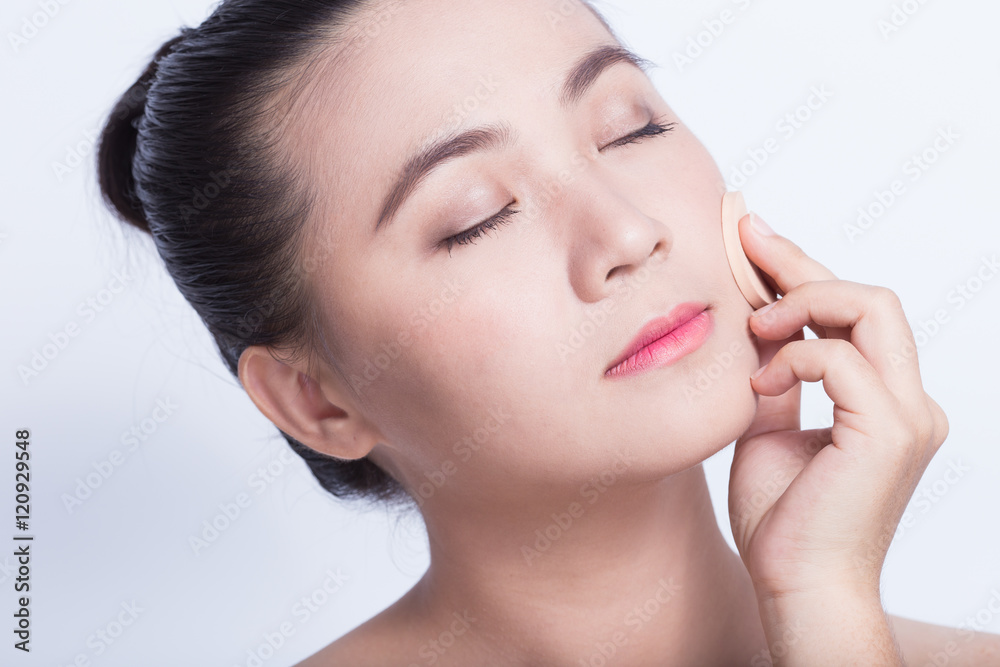 Woman applying foundation with sponge