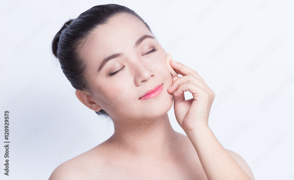Woman applying foundation with sponge