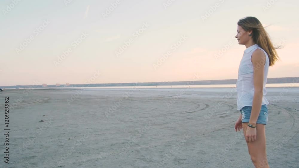 Young female playing and training labrador retriever dog on the beach at sunset Young female playing and training labrador retriever dog on the beach at sunset