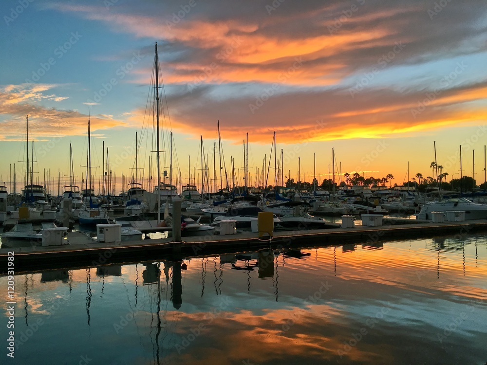 Colorful sunset over boat marina, dramatic clouds with copy space