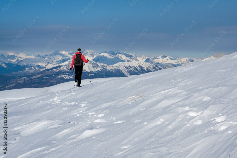 Girl walking alone one the snowed Alps