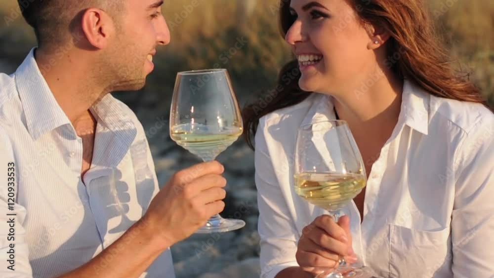 Happy couple drinking wine on the beach, selective focus Happy couple drinking wine on the beach, selective focus