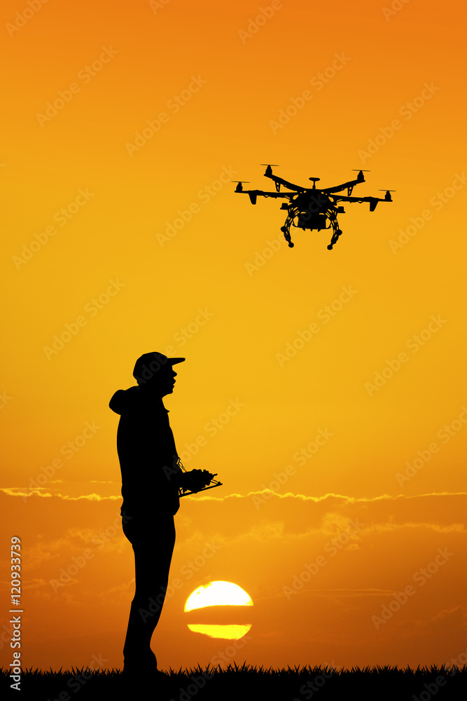 man with drone at sunset - obrazy, fototapety, plakaty 