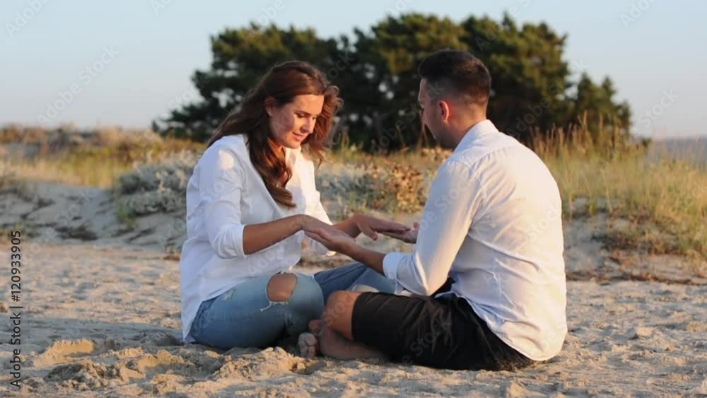 Lovely couple sitting on the beach, selective focus