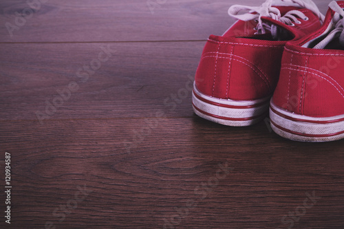 Old canvas shoes on a wooden floor Vintage Retro Filter. © Christopher Hall