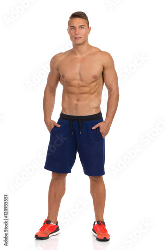 Fit Young Man In Shorts Posing With Hands In Pockets