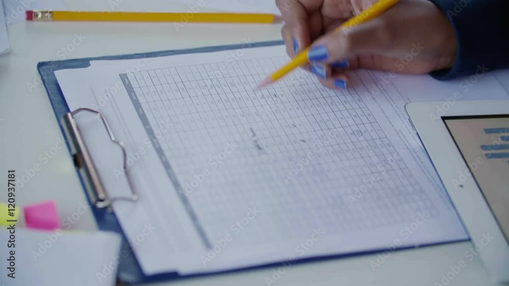 Close up hand of young woman with blue nails working at desk and analyzing Graph