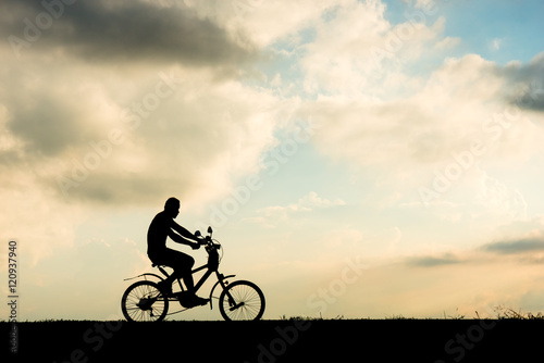 Silhouette of cyclist motion on sunset background © songdech17