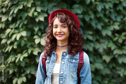 Beautiful young girl posing on green foliage background