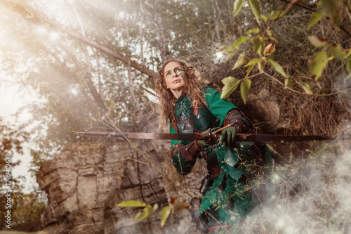 Elf woman in green leather armor with the bow and arrows