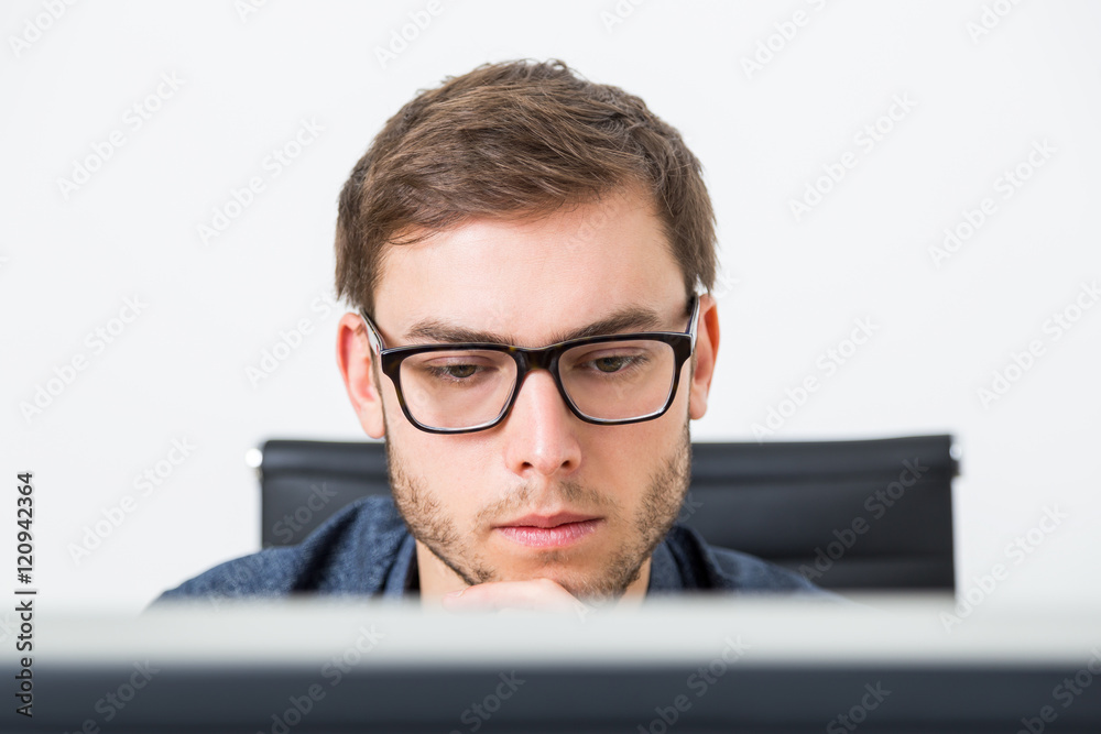 Young man in glasses analyzing data Young man in glasses analyzing data
