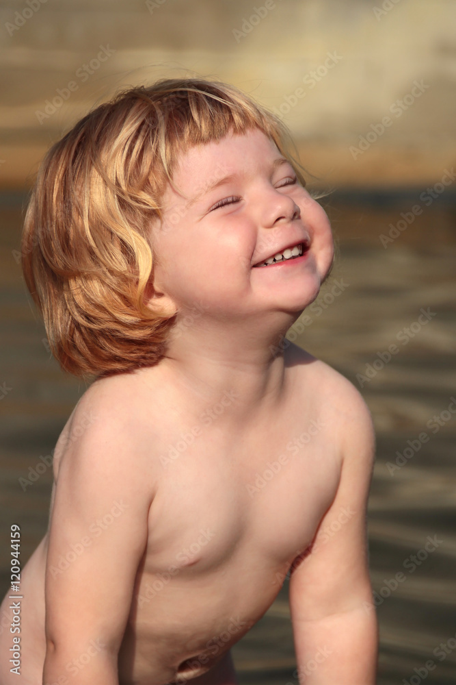 Kleines rotblondes Mädchen lacht und freut sich beim Baden im Wasser Kleines rotblondes Mädchen lacht und freut sich beim Baden im Wasser