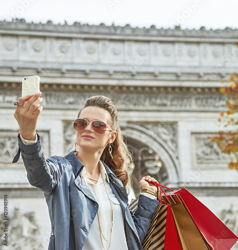 young woman shopper in Paris, France taking selfie with phone photo