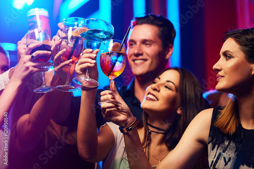 Photo Portrait of joyful friends toasting at party in the club