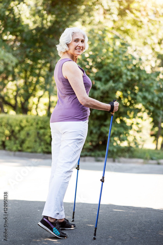 Full length figure of elderly woman with walking sticks