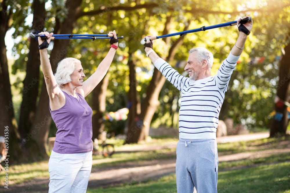 Obraz premium Good productive physical training of elderly couple in summer park