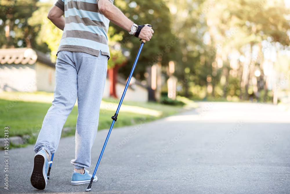 Elderly man moving along his neighborhood with tracking stick Elderly man moving along his neighborhood with tracking stick