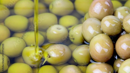 Pouring olive oil on green olives , 1080 HD video photo